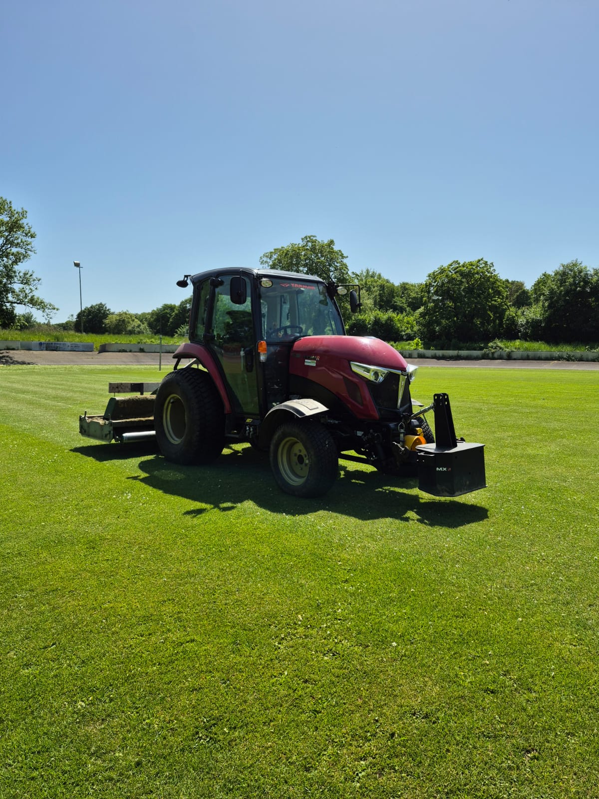 Traktor auf gepflegtem Sportrasen